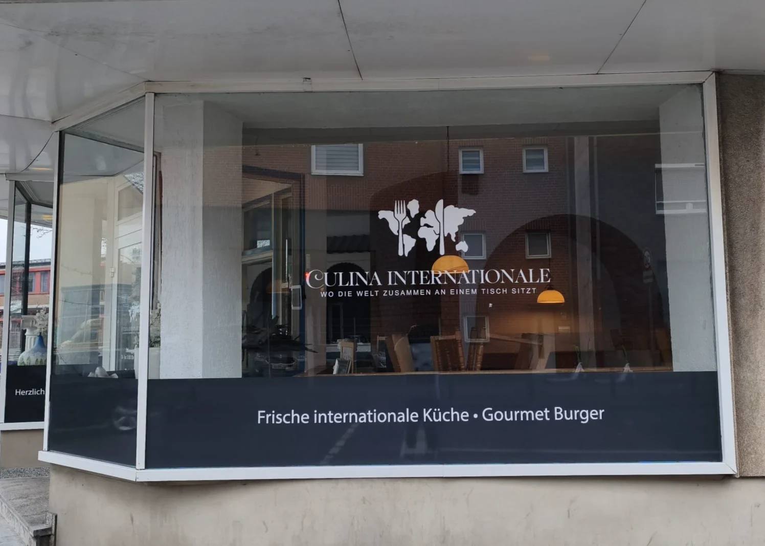 Weiße Folienbeschriftung am Schaufenster von Culina Internationale